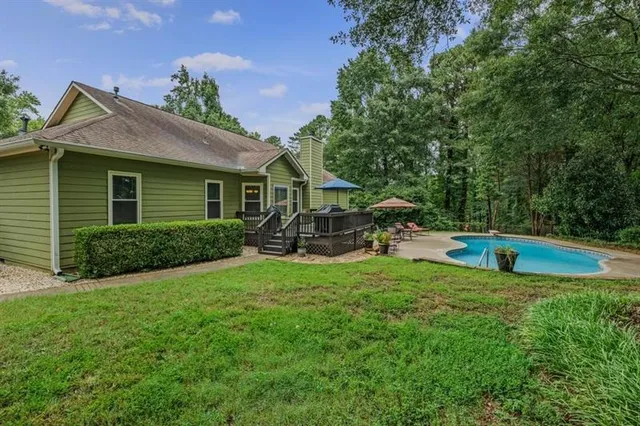 a swimming pool with outdoor seating and yard