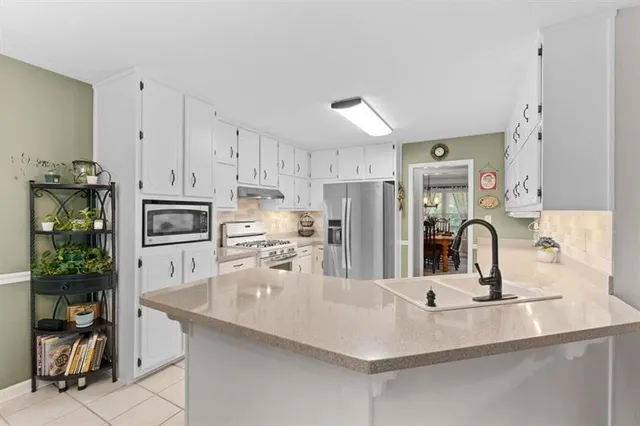 a kitchen with stainless steel appliances a sink a stove and refrigerator