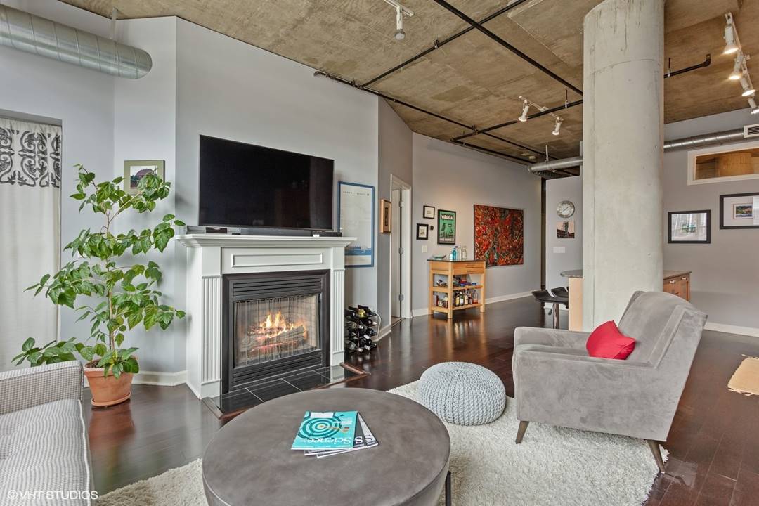 111 South Morgan Street, Unit 711 Chicago, IL 60607 - Photo 2 of 11 a living room with furniture and a fireplace
