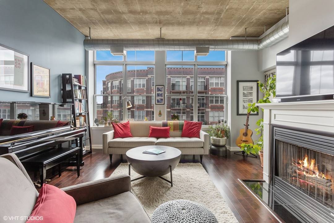 111 South Morgan Street, Unit 711 Chicago, IL 60607 - Photo 3 of 11 a living room with furniture a fireplace and a floor to ceiling window