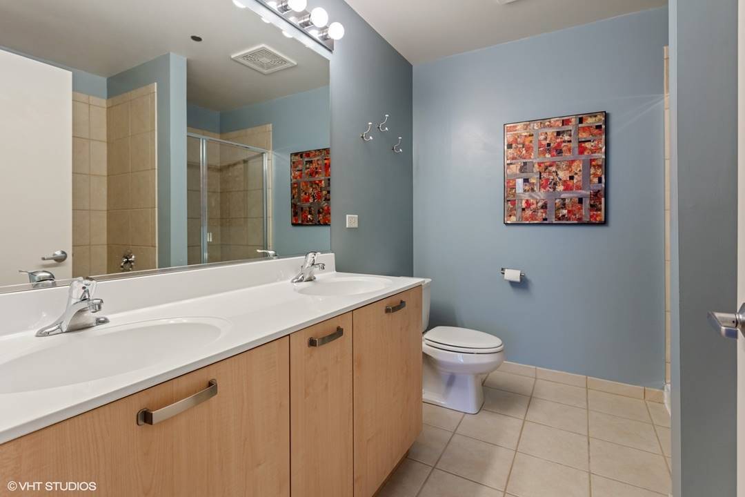 111 South Morgan Street, Unit 711 Chicago, IL 60607 - Photo 7 of 11 a bathroom with a toilet a sink and mirror