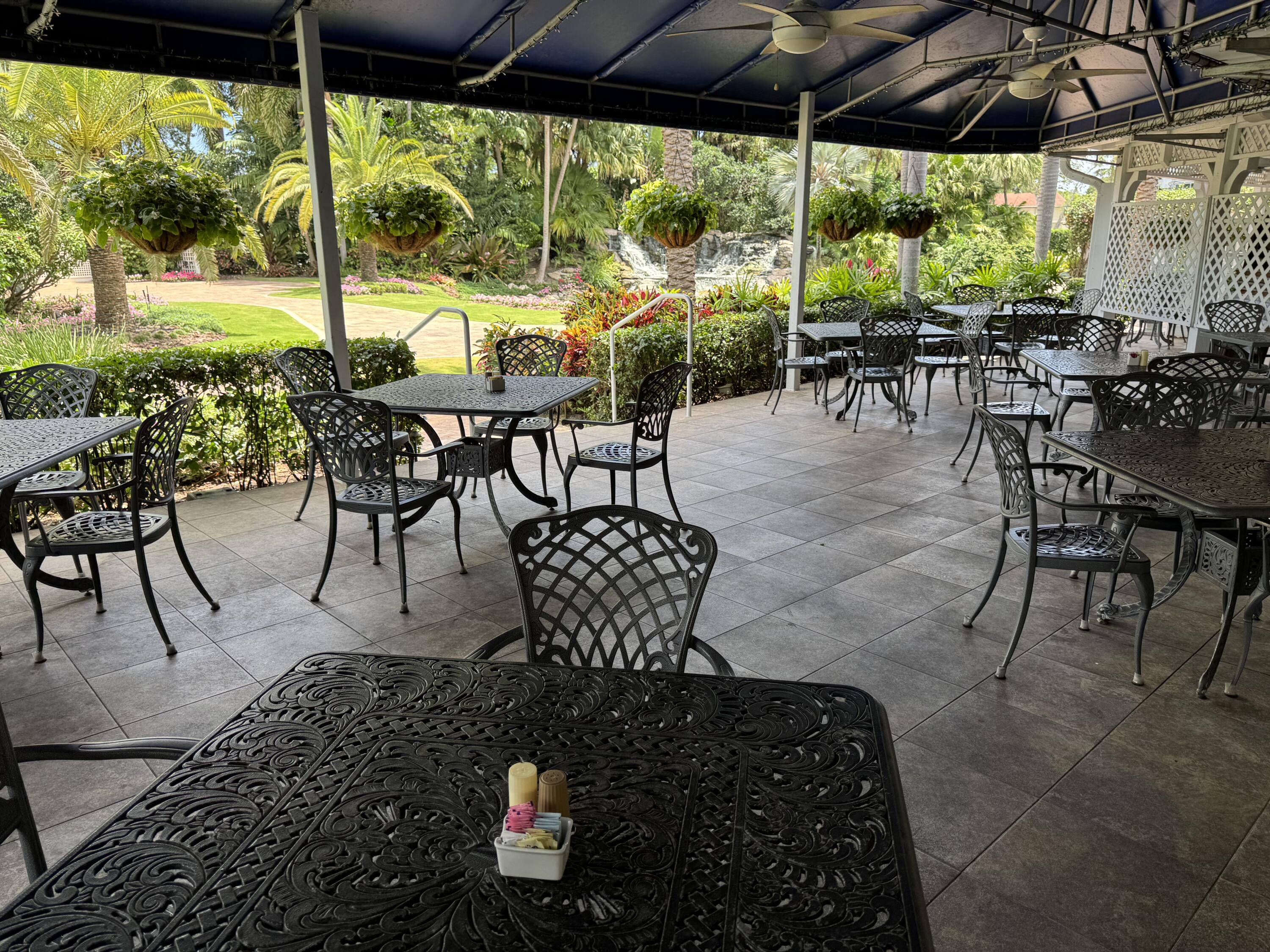 297 Deer Creek Boulevard, Unit 1305 Deerfield Beach, FL 33442 - Photo 47 of 51 a view of a patio with table and chairs and floor to ceiling window