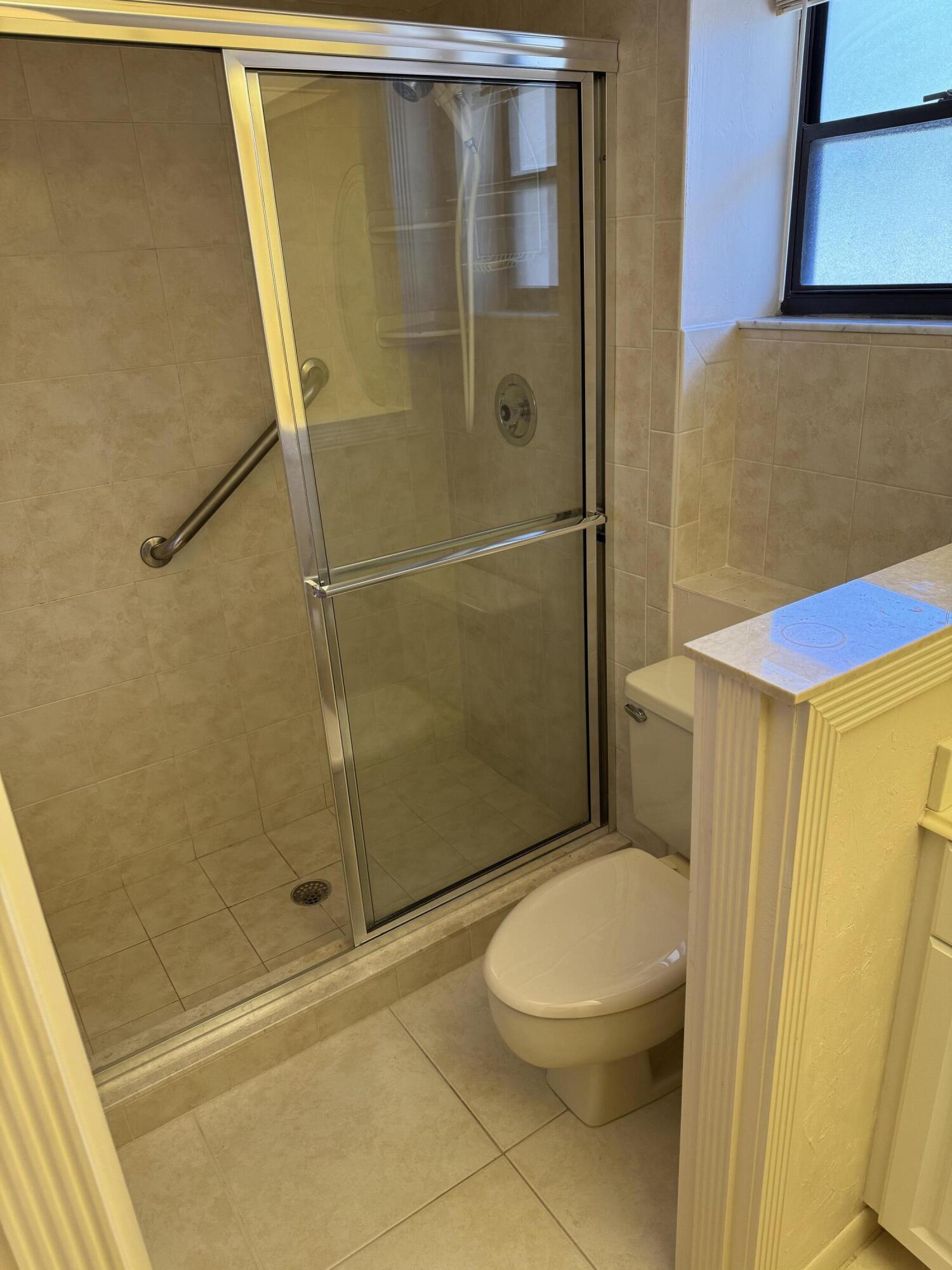 297 Deer Creek Boulevard, Unit 1305 Deerfield Beach, FL 33442 - Photo 7 of 51 a bathroom with a toilet and shower
