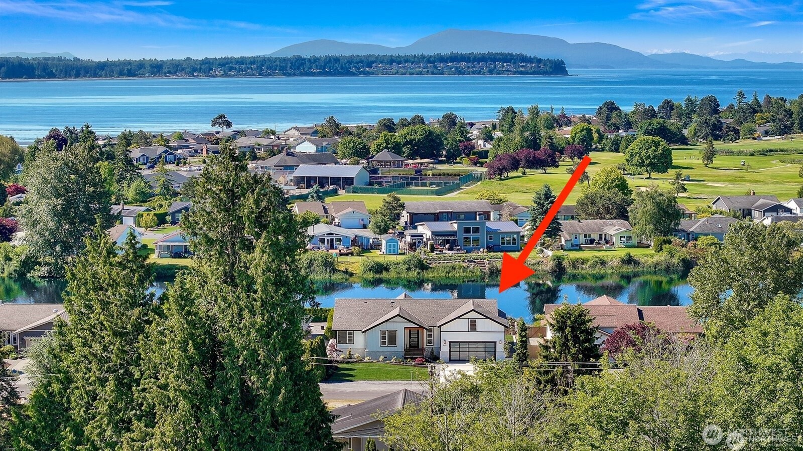 a view of a lake with a house and a big yard
