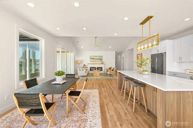 a view of a kitchen with kitchen island granite countertop wooden floor and stainless steel appliances