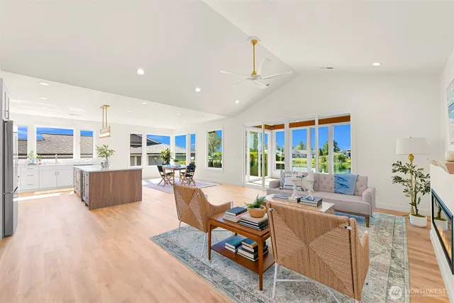 a living room with furniture kitchen view and a wooden floor