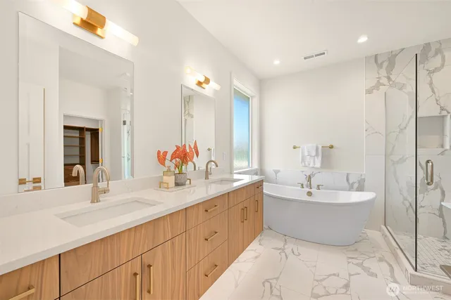 a spacious bathroom with a double vanity sink mirror and bathtub