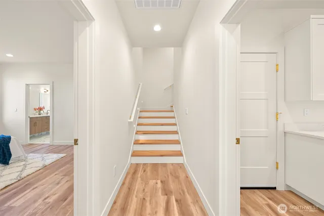 a view of a hallway with wooden floor and entryway