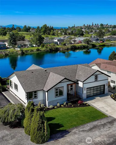 an aerial view of a house with garden space and lake view