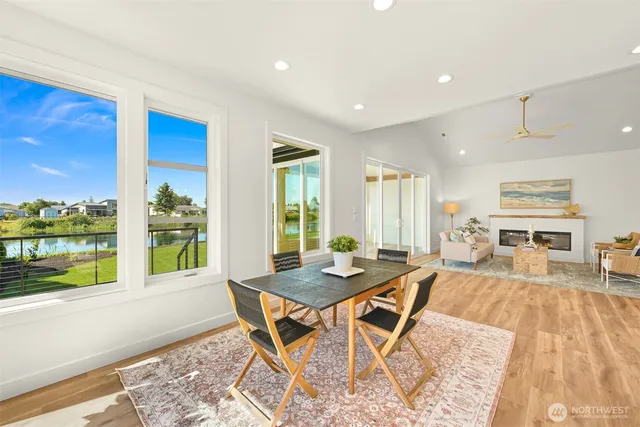 a view of a dining room with furniture large windows and wooden floor