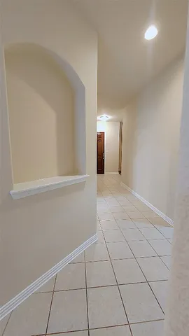 a view of an empty room with chandelier and wooden floor