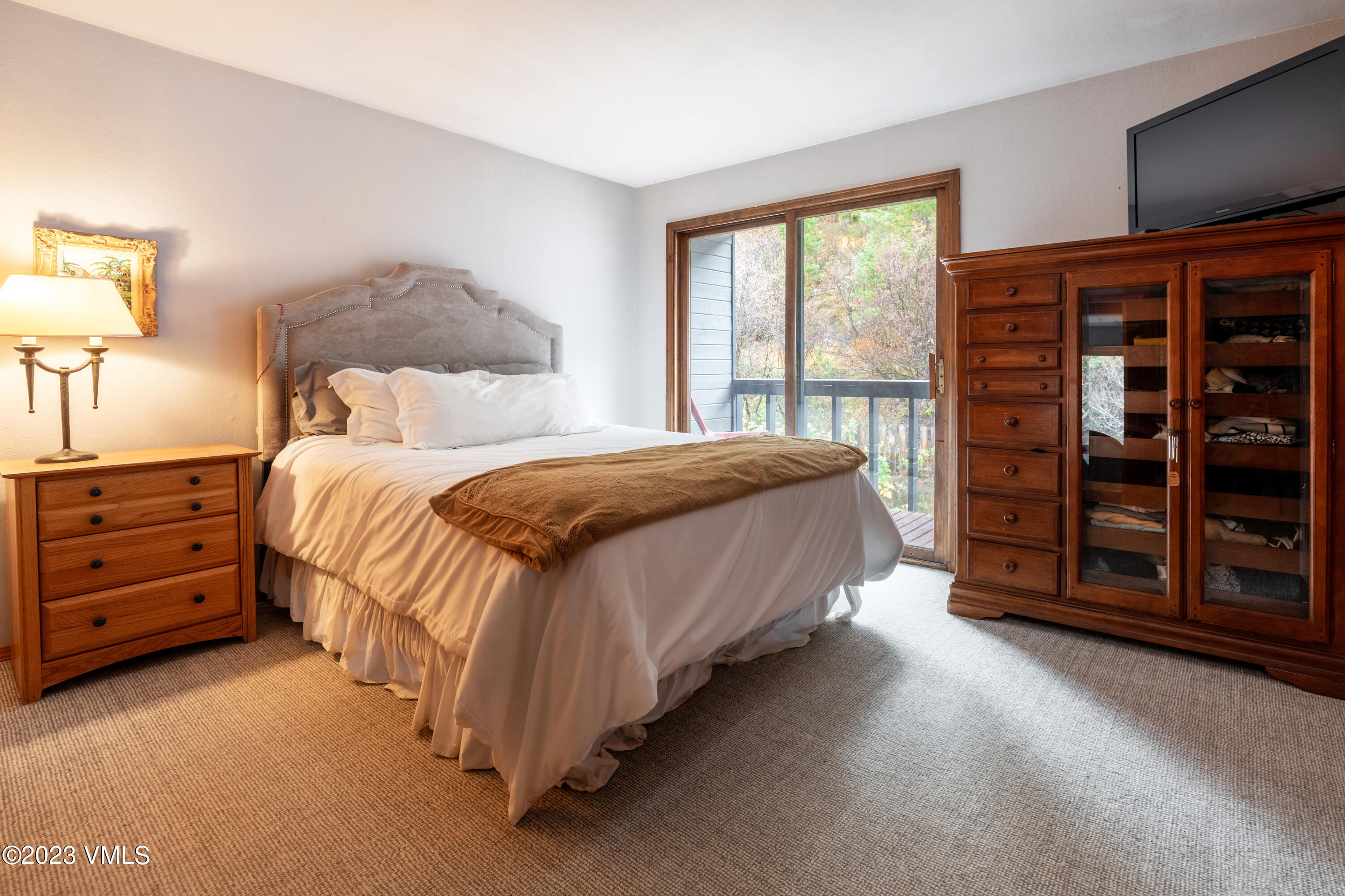 1176 Deer Boulevard, Unit A Avon, CO 81620 - Photo 7 of 8 a bedroom with a bed a dresser and a large window
