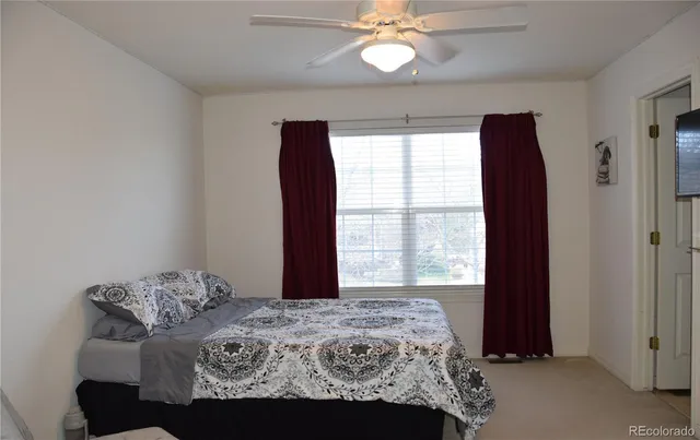 a bedroom with a large bed and a window