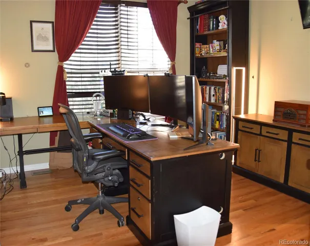 a view of a workspace with furniture and wooden floor