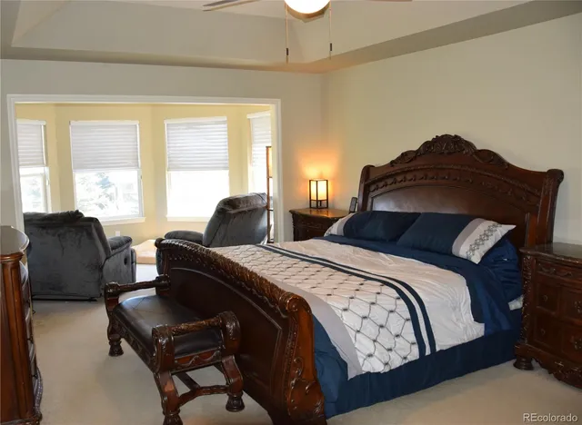 a bedroom with a bed lamp and a large window