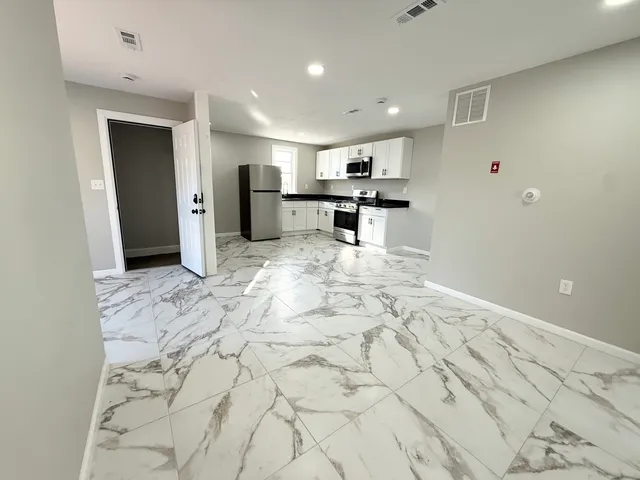 a view of kitchen with refrigerator and a sink