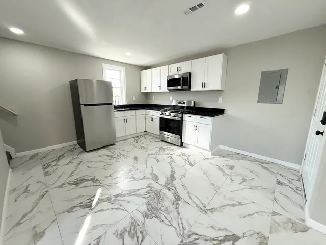 a kitchen with stainless steel appliances granite countertop a refrigerator sink and stove