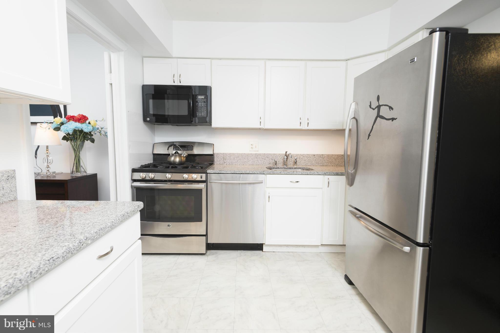 5 Hamill Road, Unit 5C Baltimore, MD 21210 - Photo 11 of 24 a kitchen with stainless steel appliances white cabinets and a refrigerator