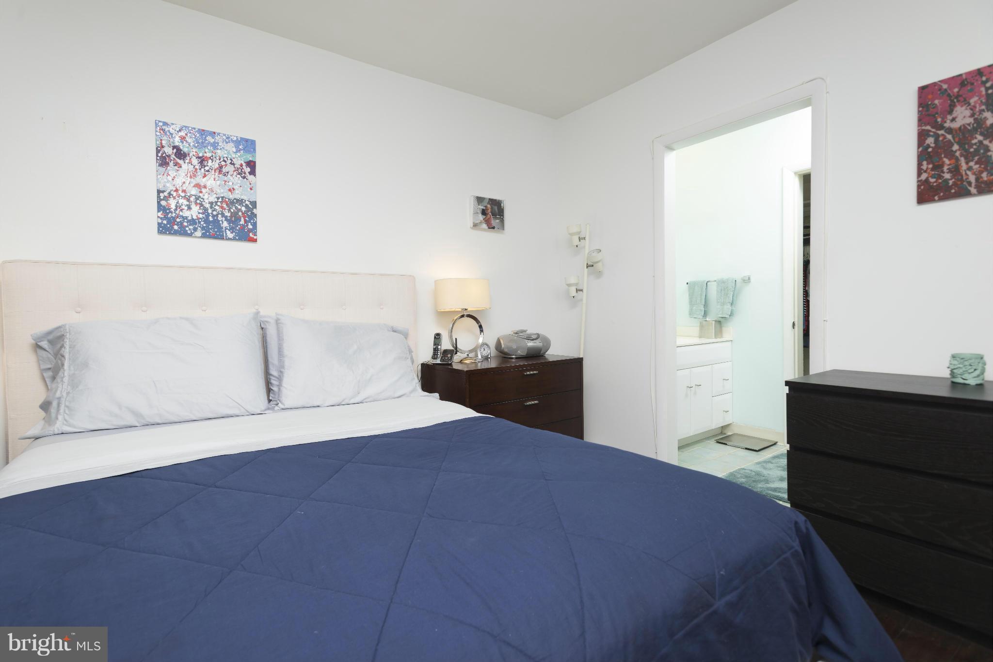5 Hamill Road, Unit 5C Baltimore, MD 21210 - Photo 16 of 24 a bedroom with a bed and a painting on the wall