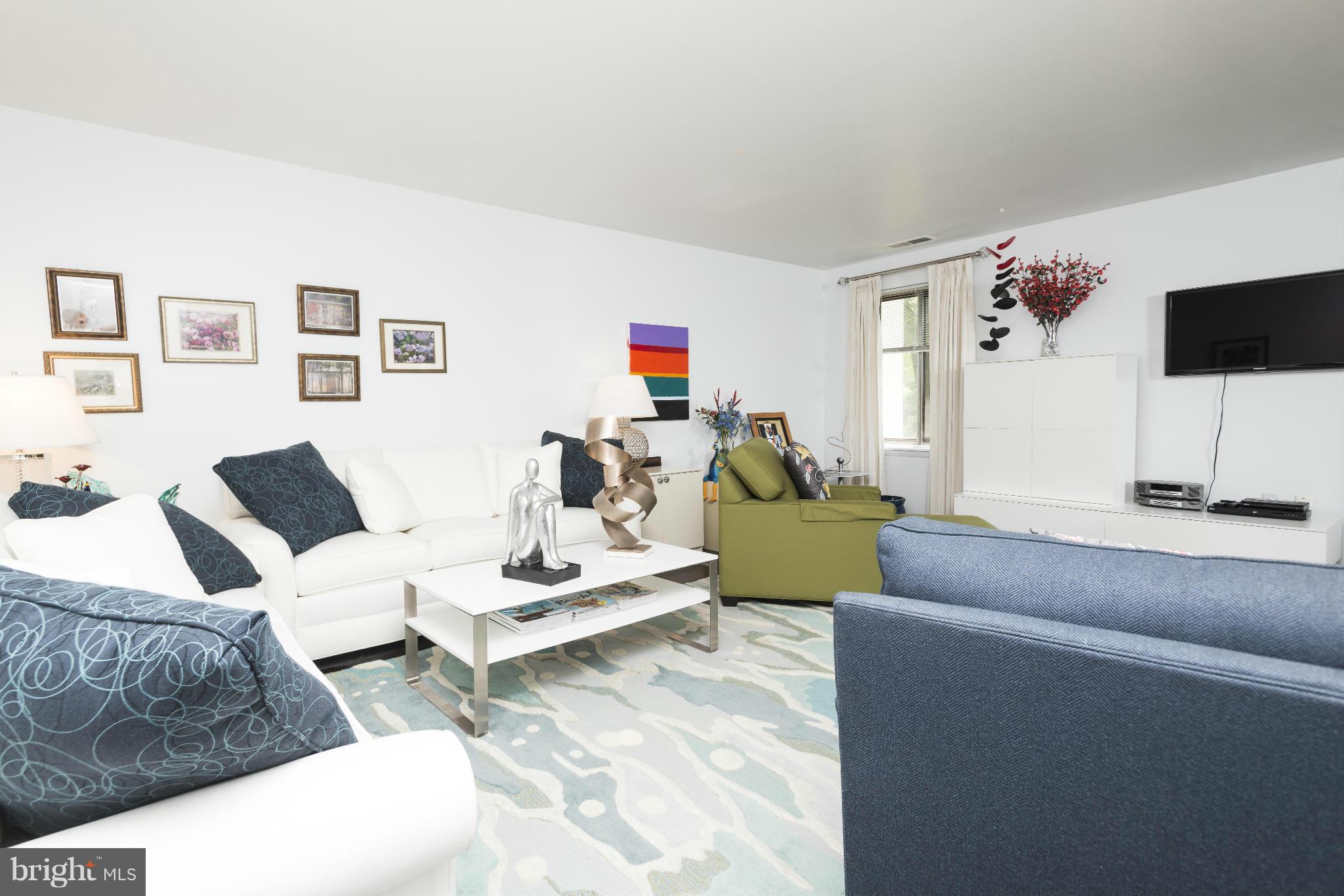 5 Hamill Road, Unit 5C Baltimore, MD 21210 - Photo 5 of 24 a living room with furniture and a flat screen tv