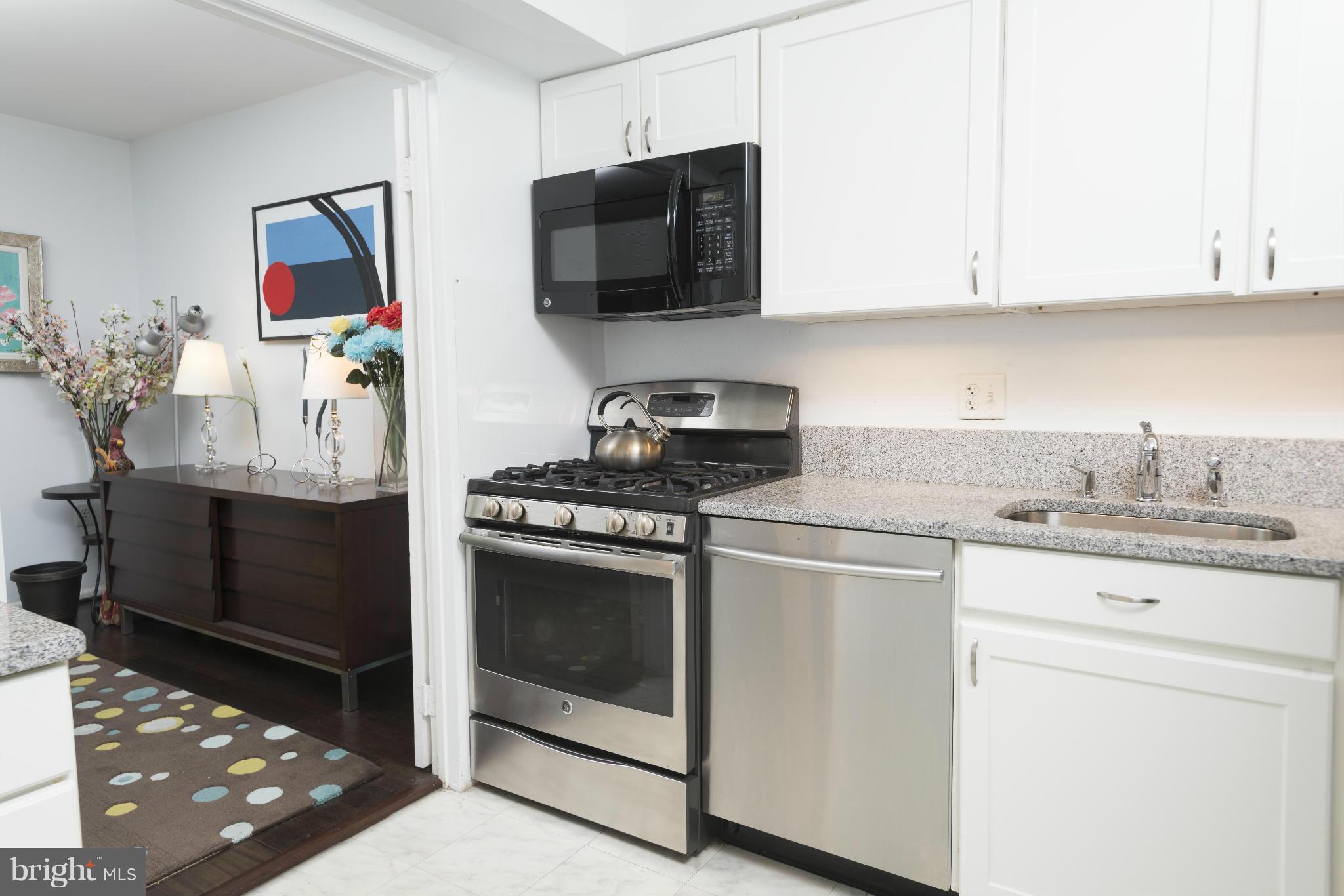 5 Hamill Road, Unit 5C Baltimore, MD 21210 - Photo 10 of 24 a kitchen with stainless steel appliances granite countertop a stove and a microwave