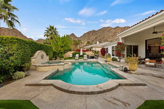 a swimming pool with outdoor seating and barbeque oven