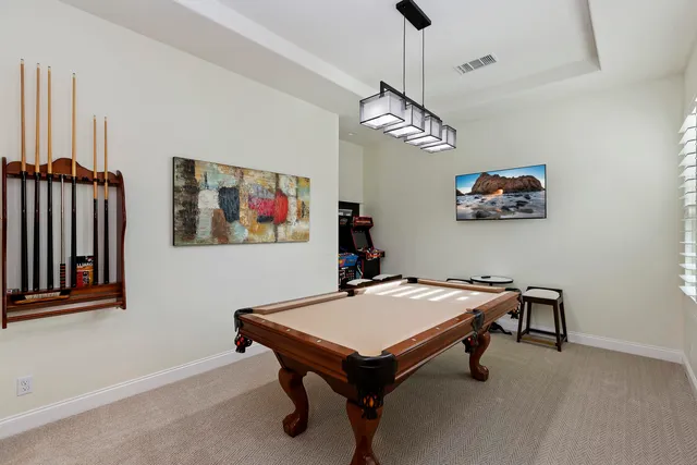 a room with wooden floor and pool table