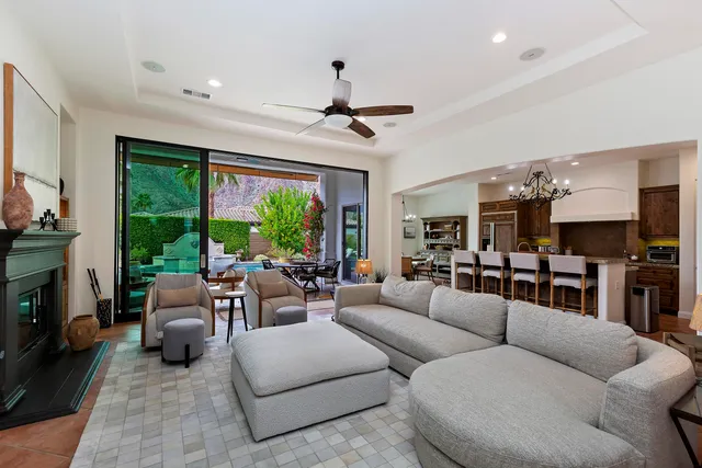 a living room with furniture fireplace and a large window
