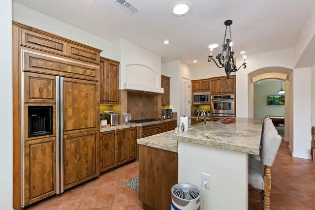 a kitchen with stainless steel appliances granite countertop a sink refrigerator and cabinets