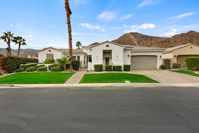 a view of house with a big yard and potted plants
