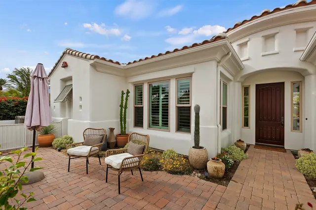 a view of a patio with couches table and chairs and potted plants