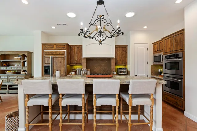 a kitchen with a dining table chairs stainless steel appliances and cabinets