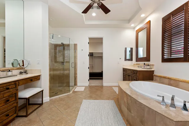 a spacious bathroom with a granite countertop tub sink shower and mirror