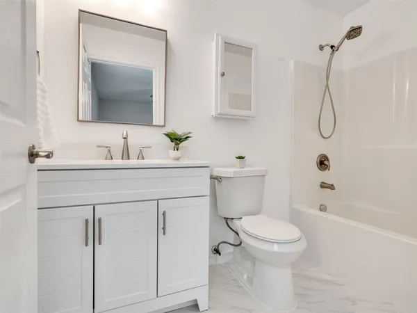 a bathroom with a sink toilet vanity and shower