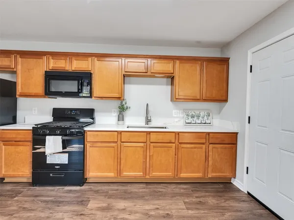 a kitchen with stainless steel appliances granite countertop a stove a sink and a microwave