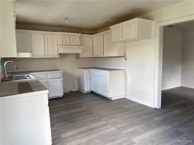 a view of a house with a large window and potted plants