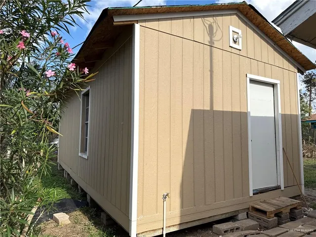 an empty room with wooden floor chandelier fan and windows