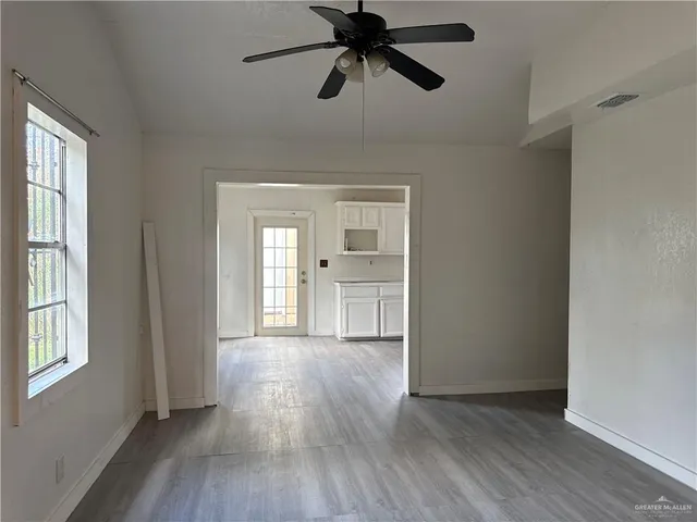 a view of a room with a window and wooden floor