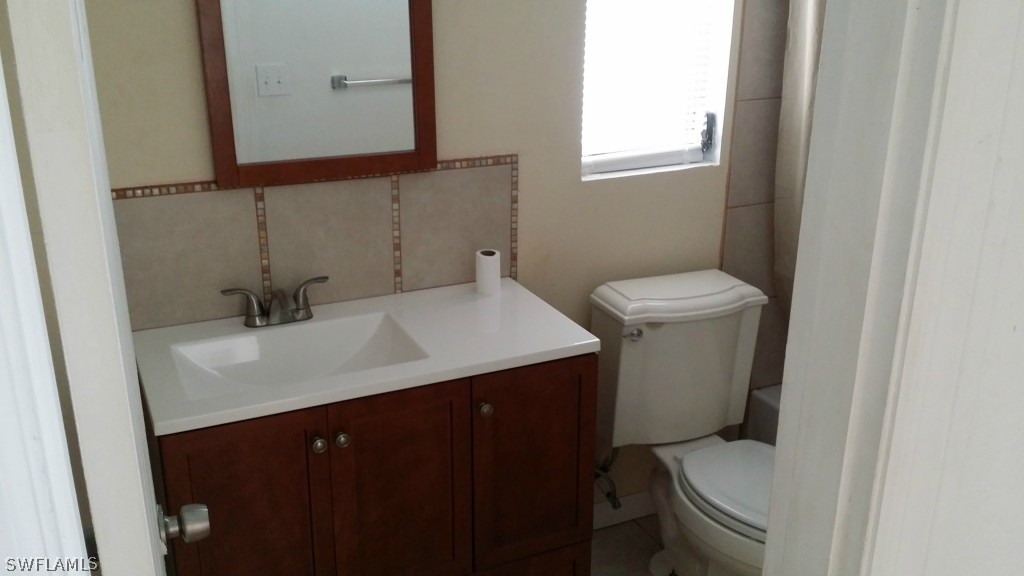 102 Jasmine Road West Lehigh Acres, FL 33936 - Photo 8 of 12 a bathroom with a sink toilet and mirror