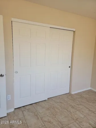an empty room with a window and a fan