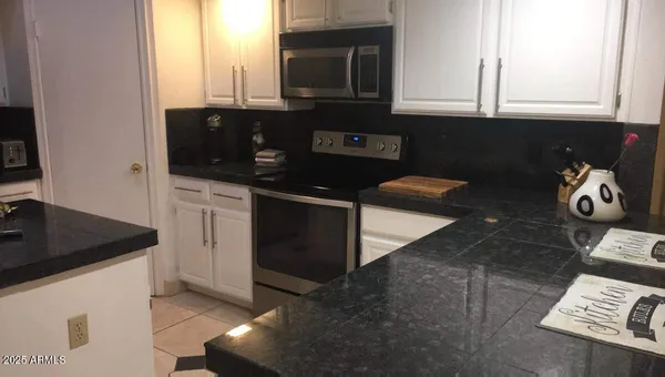 a kitchen with stainless steel appliances granite countertop a sink and a stove