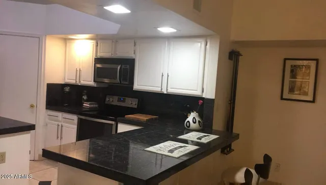 a kitchen with granite countertop stainless steel appliances a sink stove and refrigerator