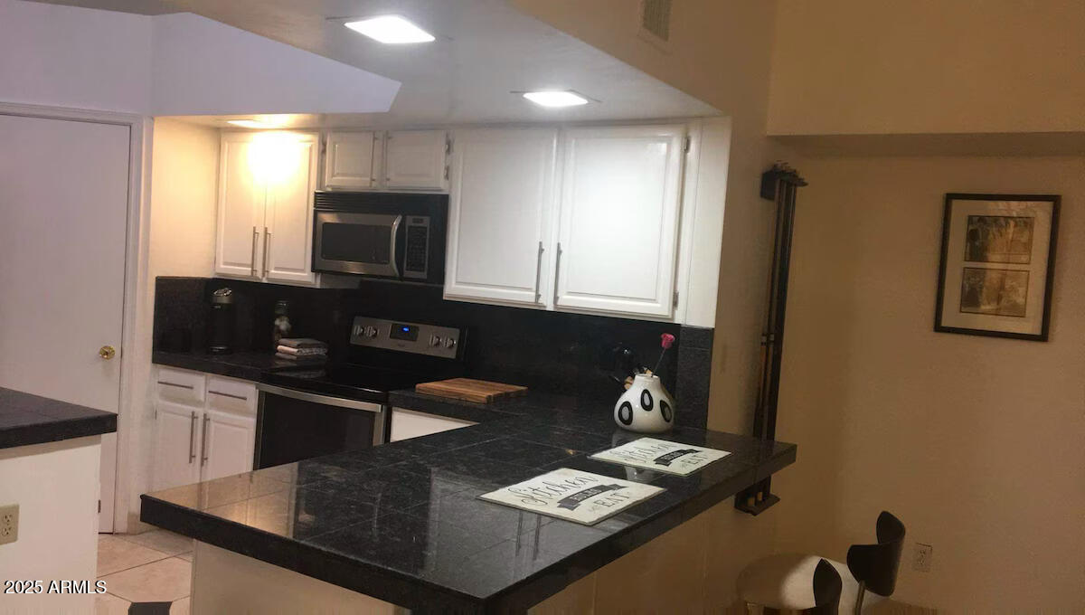 10413 North 45th Place Phoenix, AZ 85028 - Photo 5 of 25 a kitchen with granite countertop stainless steel appliances a sink stove and refrigerator