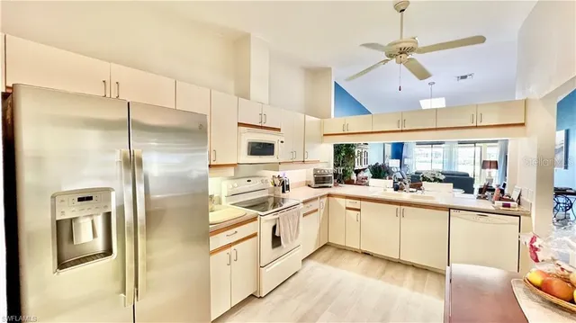 a kitchen with stainless steel appliances a sink a refrigerator and cabinets