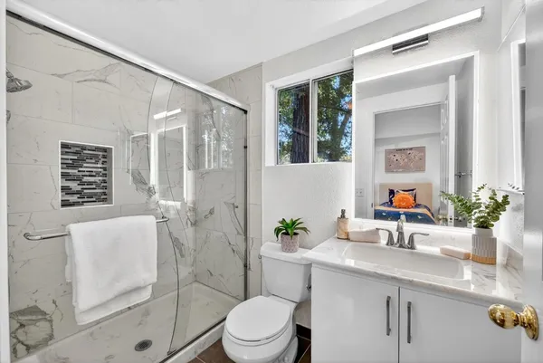 a bathroom with a sink a toilet and shower
