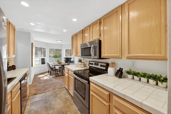 a kitchen with stainless steel appliances a stove a sink a microwave and cabinets