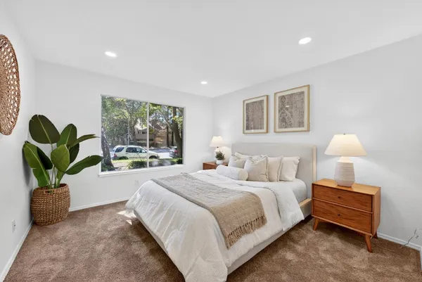 a bedroom with a bed and a potted plant