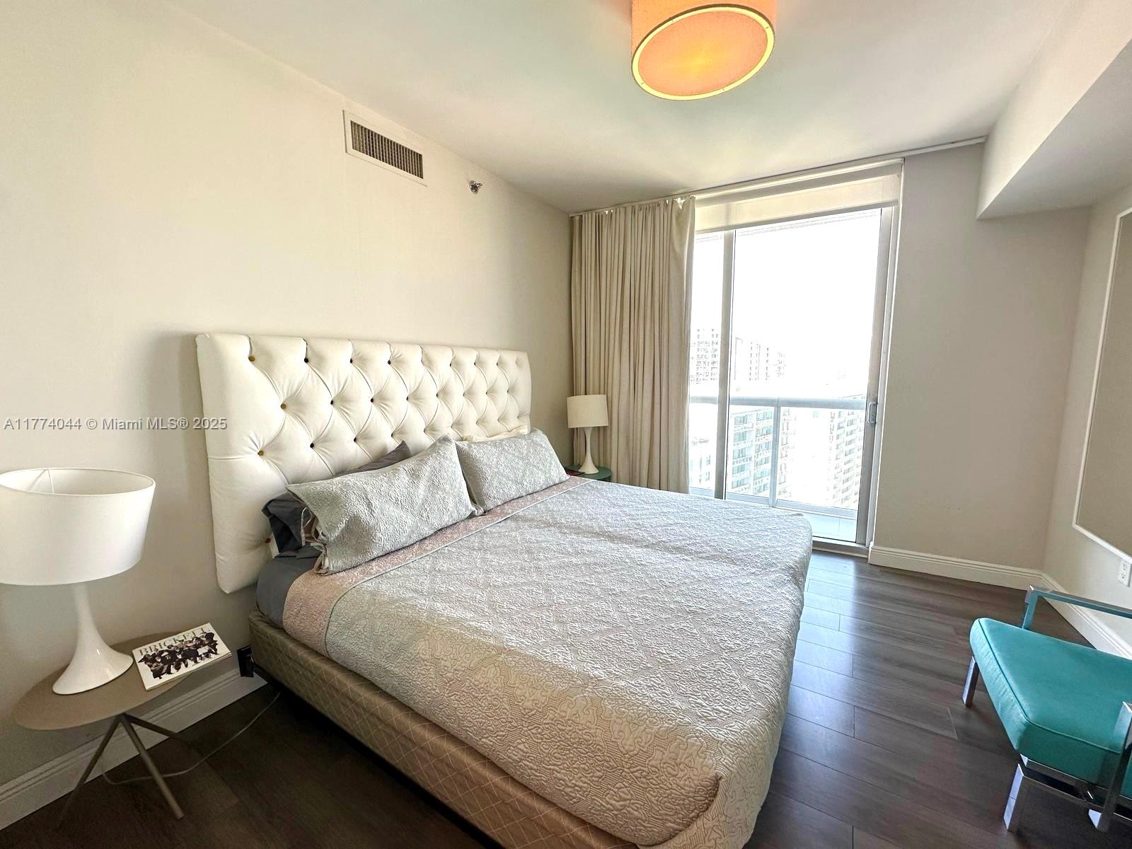 485 Brickell Avenue, Unit 4408 Miami, FL 33131 - Photo 11 of 15 a bedroom with a bed and a lamp next to a window
