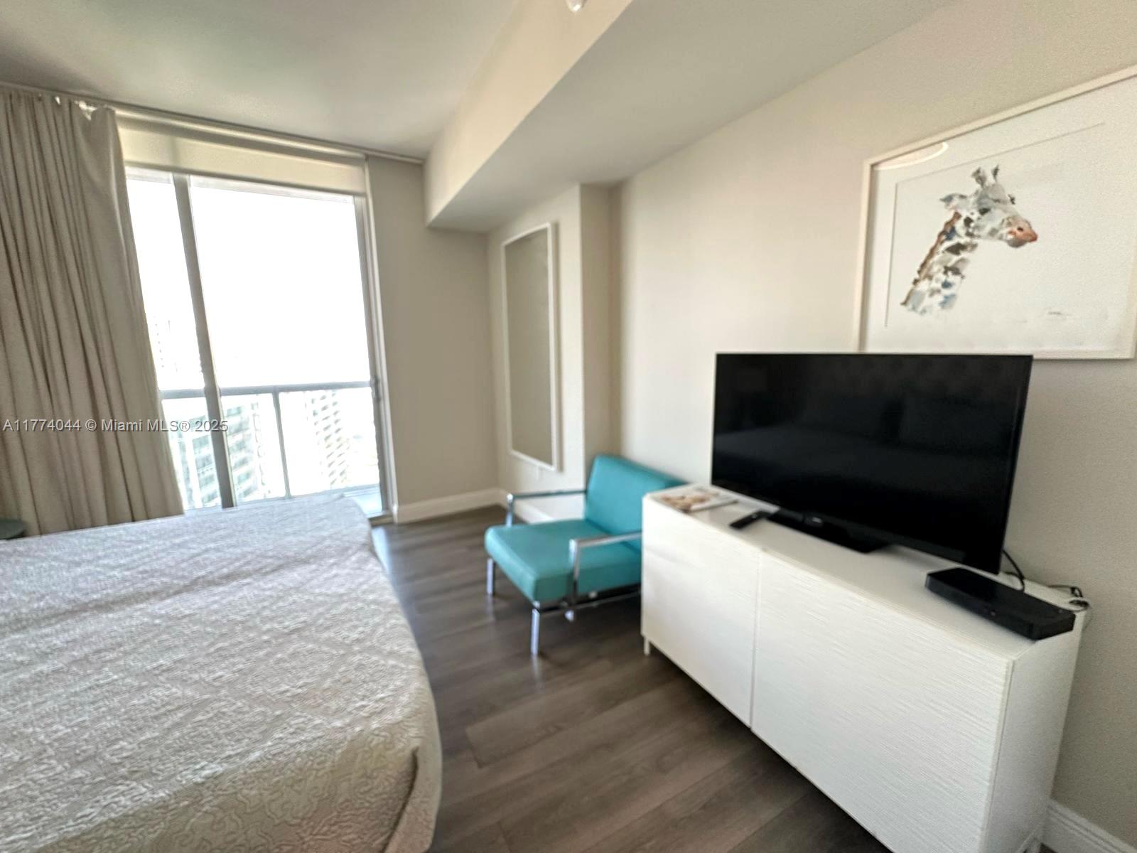 485 Brickell Avenue, Unit 4408 Miami, FL 33131 - Photo 12 of 15 a living room with a flat screen tv and a window