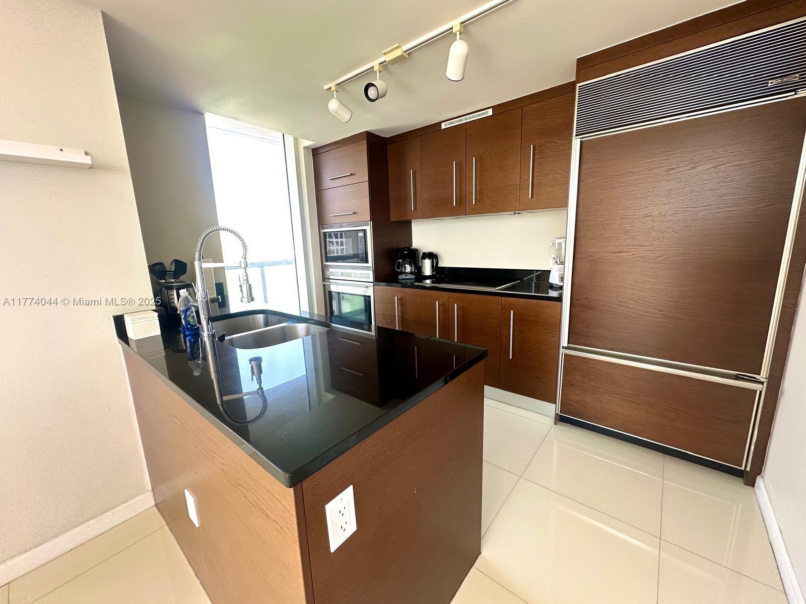 485 Brickell Avenue, Unit 4408 Miami, FL 33131 - Photo 6 of 15 a kitchen with stainless steel appliances granite countertop a refrigerator a sink and a stove